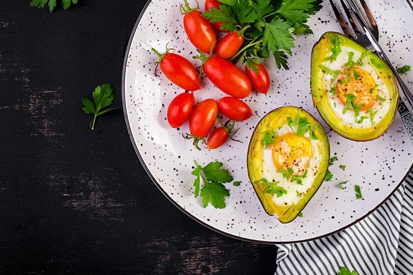 Avocado baked with egg and fresh salad. Vegetarian dish. Top view, overhead.  Ketogenic diet. Keto food