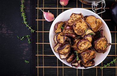 Koyu bir masada İtalyan güneşte kurutulmuş patlıcan. Korunmuş yiyecek. İtalyan mezesi. Üstte görüntü