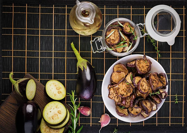 Italian sun-dried eggplant on a dark table. Preserved food. Italian appetizer. Top view