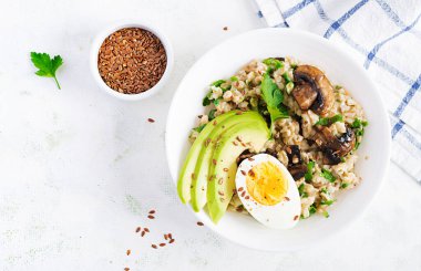 Yeşil mantar, haşlanmış yumurta, avokado ve keten tohumlu yulaf lapası. Sağlıklı dengeli yiyecekler. Üst görünüm, genel görünüm, kopyalama alanı