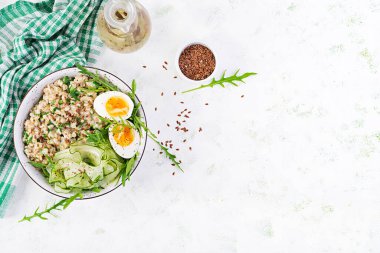 Yeşil otlu yulaf lapası, haşlanmış yumurta, salatalık ve keten tohumu. Sağlıklı dengeli yiyecekler. Üst görünüm, genel görünüm, kopyalama alanı