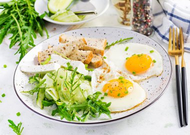 İngiliz kahvaltısı. Yağda yumurta, peynir, salatalık ve roka. Amerikan yemekleri..