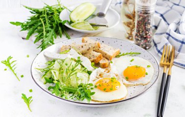 İngiliz kahvaltısı. Yağda yumurta, peynir, salatalık ve roka. Amerikan yemekleri..