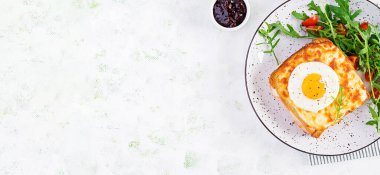 Kahvaltıda. Sıcak sandviç. Croque madame sandviçi ve masada bir fincan sütlü kahve. Fransız mutfağı. Üst görünüm, genel görünüm, kopyalama alanı