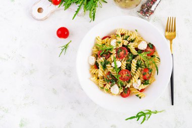 Makarna salatası. Fusilli Makarna - Domatesli Caprese salatası, mozzarella ve fesleğen. Üst görünüm, düz görünüm, kopyalama alanı