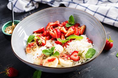 Süzme peynir ya da çilekli peynir, muz, mavi kasede ceviz. Sağlıklı yemek..