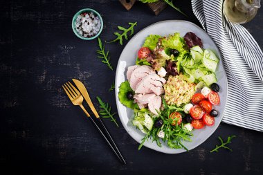 Ketogenik diyet. Haşlanmış domuz eti, avokado guacamole, domates, salatalık, mozzarella peyniri, siyah zeytin ve roka ile akşam yemeği. Detoks ve sağlıklı konsept. Keto yemeği. Yukarıdan, yukarıdan.