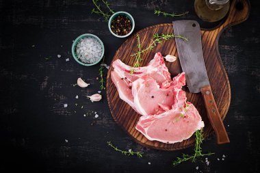 Karanlık masada çiğ domuz bifteği. Üst görünüm, genel görünüm, kopyalama alanı