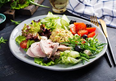 Ketogenik diyet. Haşlanmış domuz eti, avokado guacamole, domates, salatalık, mozzarella peyniri, siyah zeytin ve roka ile akşam yemeği. Detoks ve sağlıklı konsept. Keto yemeği..