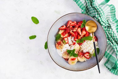 Süzme peynir ya da çilekli peynir, muz, mavi kasede ceviz. Sağlıklı yiyecekler. Üst görünüm, genel görünüm, kopyalama alanı