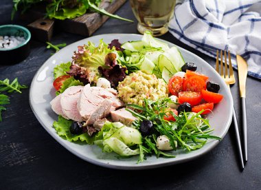 Ketogenik diyet. Haşlanmış domuz eti, avokado guacamole, domates, salatalık, mozzarella peyniri, siyah zeytin ve roka ile akşam yemeği. Detoks ve sağlıklı konsept. Keto yemeği..