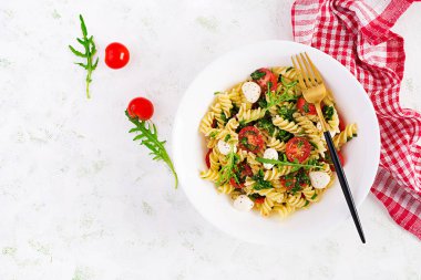 Makarna salatası. Fusilli Makarna - Domatesli Caprese salatası, mozzarella ve fesleğen. Üst görünüm, düz görünüm, kopyalama alanı