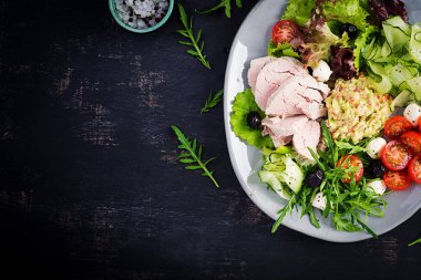 Ketogenik diyet. Haşlanmış domuz eti, avokado guacamole, domates, salatalık, mozzarella peyniri, siyah zeytin ve roka ile akşam yemeği. Detoks ve sağlıklı konsept. Keto yemeği. Yukarıdan, yukarıdan.
