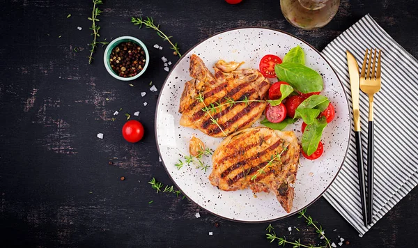 Gegrilde Varkensvlees Steaks Salade Met Tomaten Plaat Donkere Achtergrond Bovenaanzicht — Stockfoto