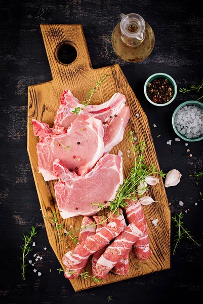 돼지고기 스테이크에요 종류의 생돼지고기 고기와 잘게썬 소시지가 어두운 식탁에 위에서 — 스톡 사진