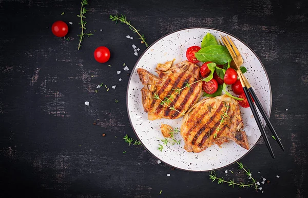 Gegrilde Varkensvlees Steaks Salade Met Tomaten Plaat Donkere Achtergrond Bovenaanzicht — Stockfoto