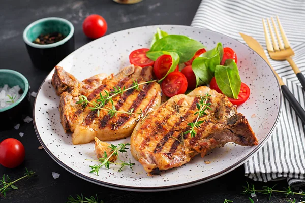 Gegrilde Varkensvlees Steaks Salade Met Tomaten Plaat Donkere Achtergrond — Stockfoto