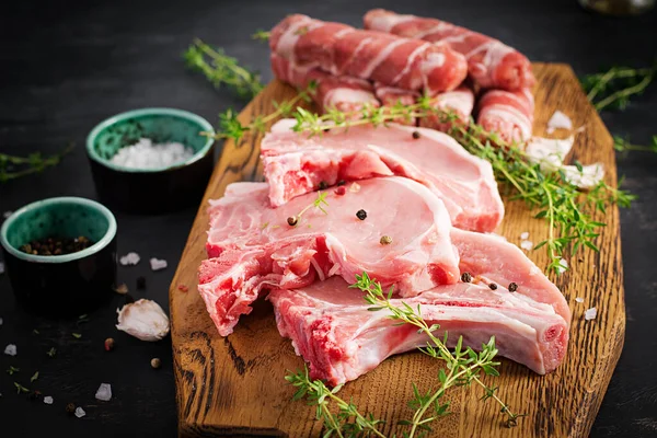 돼지고기 스테이크에요 종류의 생돼지고기 고기와 잘게썬 소시지가 어두운 식탁에 — 스톡 사진