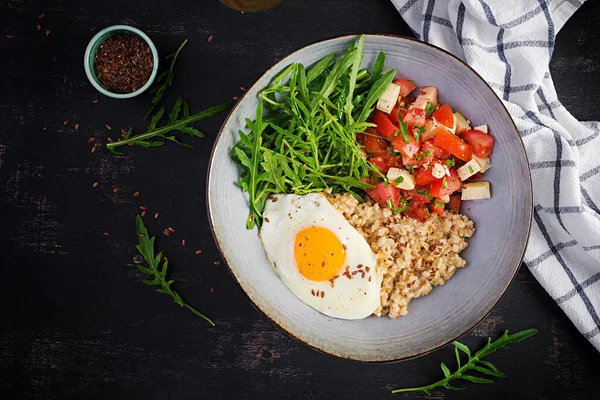 早餐燕麦粥与煎蛋 西红柿沙拉 牛油果和亚麻籽 健康均衡的食物 顶部视图 复制空间 — 图库照片