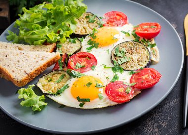 İngiliz kahvaltısı. Yağda yumurta, domates ve patlıcan. Amerikan yemekleri..