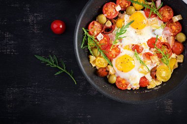 İngiliz kahvaltısı. Yağda yumurta, jambon, domates ve roka. Amerikan yemeği. Üst görünüm, genel görünüm, kopyalama alanı