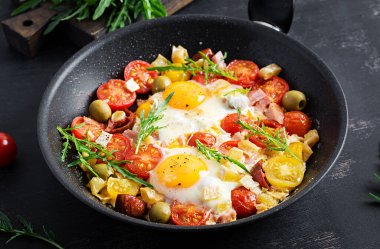 İngiliz kahvaltısı. Yağda yumurta, jambon, domates ve roka. Amerikan yemekleri..