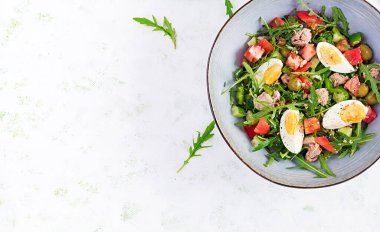 Sağlıklı yiyecekler. Yumurtalı ton balığı salatası, salatalık, domates, zeytin ve roka. Fransız mutfağı. Üst görünüm, kopyalama alanı, düz uzanma