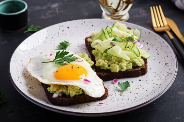 Sağlıklı kahvaltı. Avokado soslu sandviç, salatalık ve sahanda yumurta, sağlıklı kahvaltı ya da atıştırmalık için..