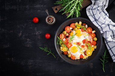 İngiliz kahvaltısı. Yağda yumurta, jambon, domates ve roka. Amerikan yemeği. Üst görünüm, genel görünüm, kopyalama alanı
