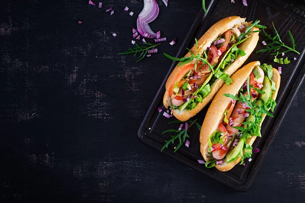 개에다 소시지 토마토 양파를 어두운 배경에 놓는다 위에서 평평하게 — 스톡 사진