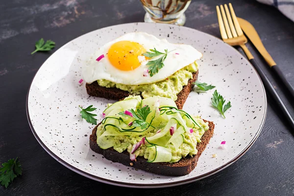 Healthy breakfast. Sandwich with avocado guacamole, cucumber and fried egg,   for healthy breakfast or snack.