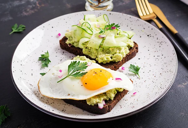 Sağlıklı kahvaltı. Avokado soslu sandviç, salatalık ve sahanda yumurta, sağlıklı kahvaltı ya da atıştırmalık için..