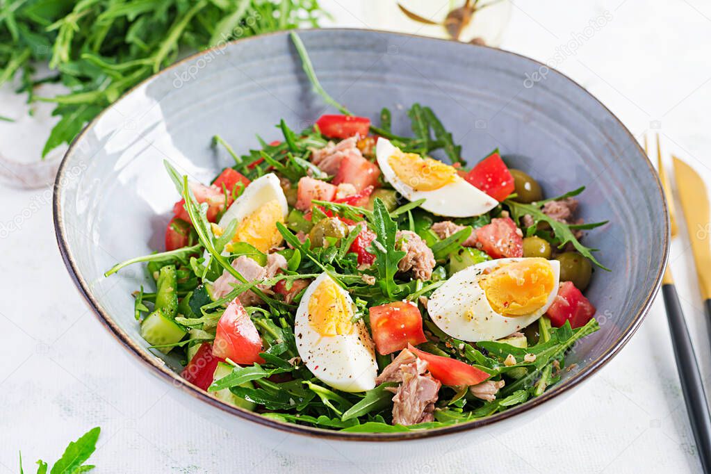 Healthy food. Tuna fish salad with eggs, cucumber, tomatoes, olives and arugula.  French cuisine.