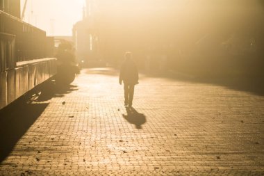 Biri arka ışık içinde gider