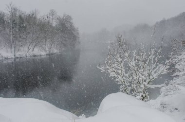 Nehir kıyısında orman kar fırtınasında