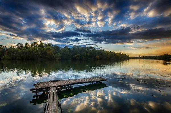 Kvällen himlen med moln återspeglas i det lugna vattnet i en bild — Stockfoto