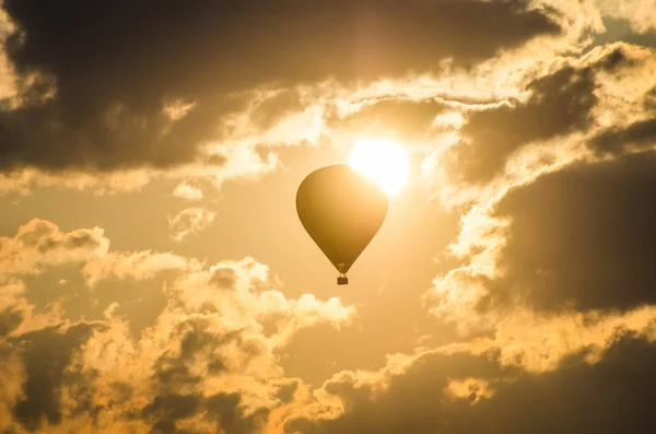 stock image The balloon flies against the background of the sun