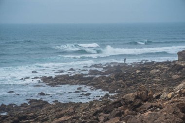 Okyanus kıyısındaki yalnız balıkçı