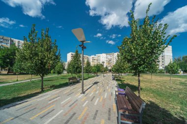 Banklar ağaçlar ve fenerler ile bir şehir parkında Alley
