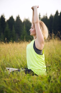 Kadınlar yazın dışarıda yoga yapıyor.