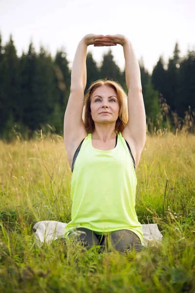 Vrouw doet yoga buiten in de zomer — Stockfoto