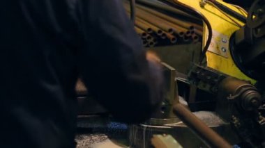 İşçi şerit testere üzerinde bir boru kesiyor