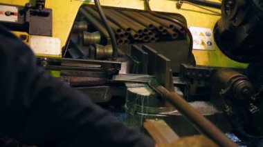 İşçi şerit testere üzerinde bir boru kesiyor