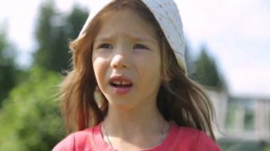 Küçük kız bahçede bektaşi üzümü yiyor.