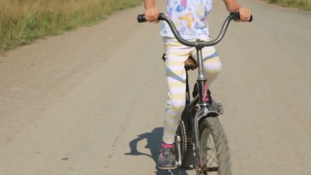 Menina montando uma bicicleta — Vídeo de Stock