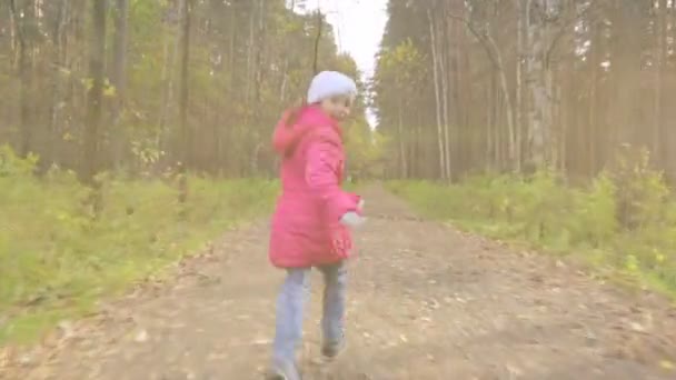 Маленькая девочка бегает в осеннем парке — стоковое видео