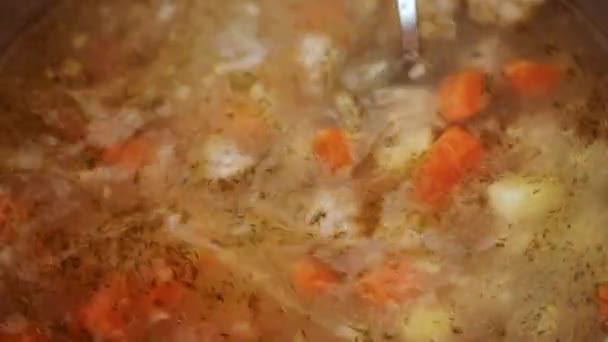 Siedende Suppe mit einem Löffel umrühren — Stockvideo