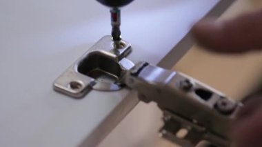 Atölyede kablosuz tornavidayla çalışan bir işçi