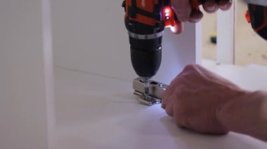 Atölyede kablosuz tornavidayla çalışan bir işçi