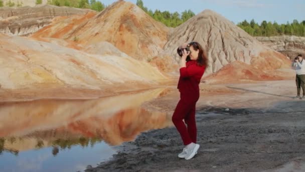 Fotografowie robiący zdjęcia na pięknym pagórkowatym krajobrazie — Wideo stockowe